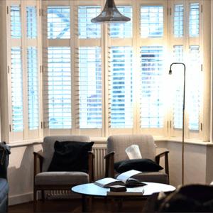 Bay window beauty! Shutters enhance the view & create a cozy reading nook.